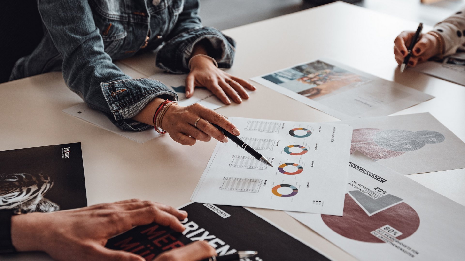 HMM – The Tourism Group Personen besprechen Diagramme und Grafiken bei einer Besprechung am Tisch